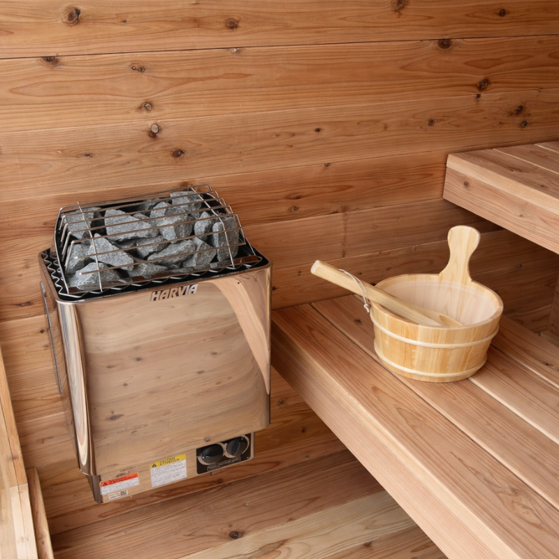 Wooden sauna with a stove and a wooden bucket with a ladle on a shelf.